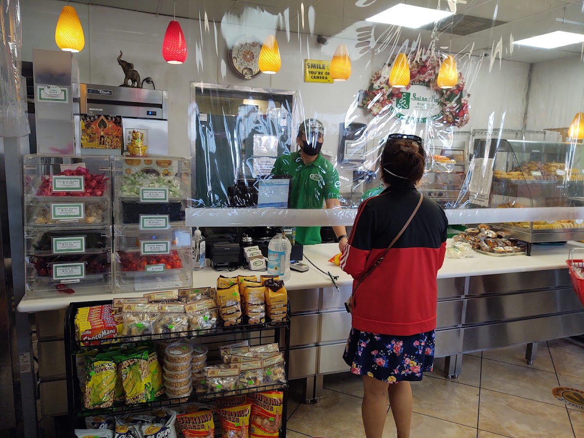 The counter at Luisa and Son with staff in green and the pastry cases behind
