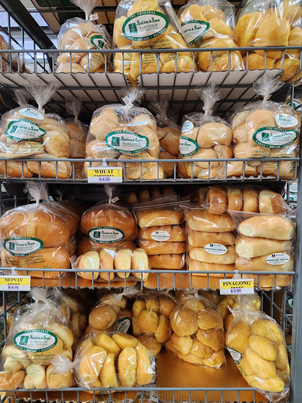 Bagged pandesal and monay bread on the wire racks